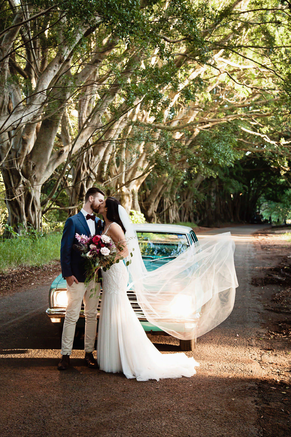 bride-and-groom-with-wedding-car_Ewingsdale-Hall_Byron_Bay-Wedding-QuincenmulberryStudios